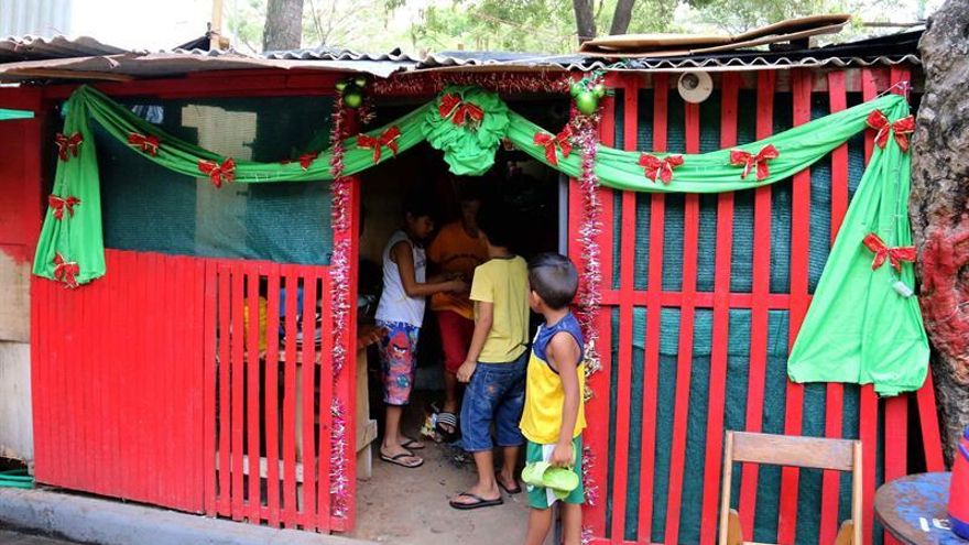 Refugiados de la inundaciones en Paraguay celebran la Navidad entre chapas y maderas
