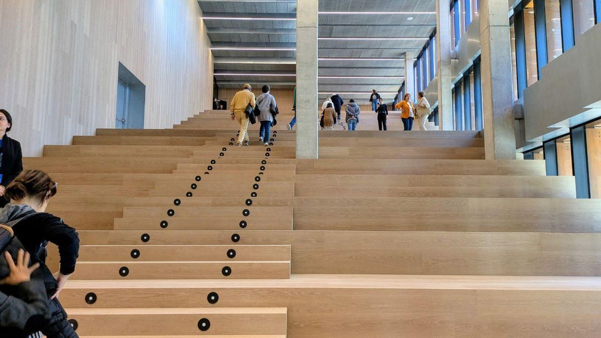 Ciudadanos por las escaleras accediendo al auditorio.