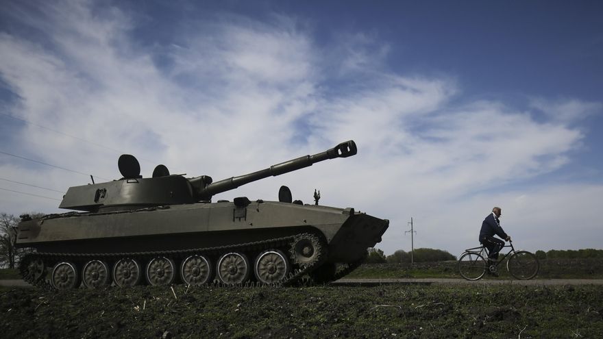 Un hombre pasea en bicicleta al lado de un tanque este sábado en la localidad ucrania de Jarkov. EFE/EPA/STRINGER