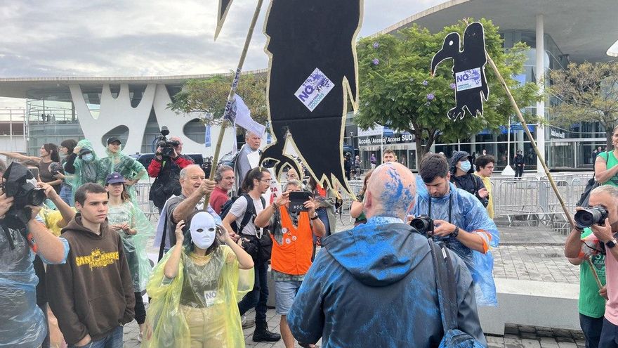 Un asistente a la feria The District discute con los manifestantes antidesahucios después de que le lanzaran polvos de colores