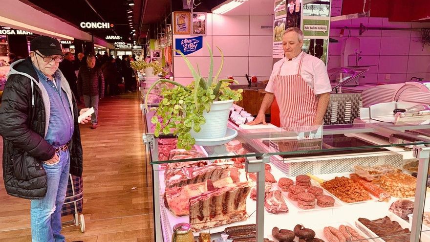 Joaquín Izaguirre, con un cliente, en la carnicería.