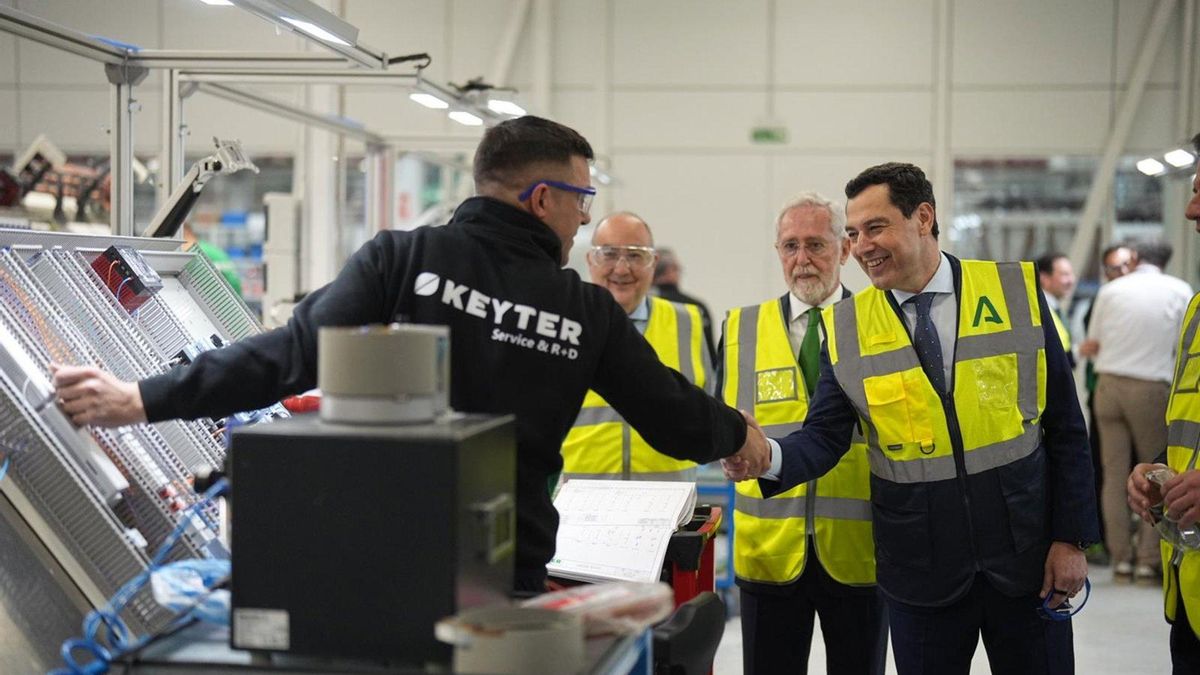 Juanma Moreno saluda a un empleado de Keyter durante su recorrido por las instalaciones de la multinacional en Lucena (Córdoba)