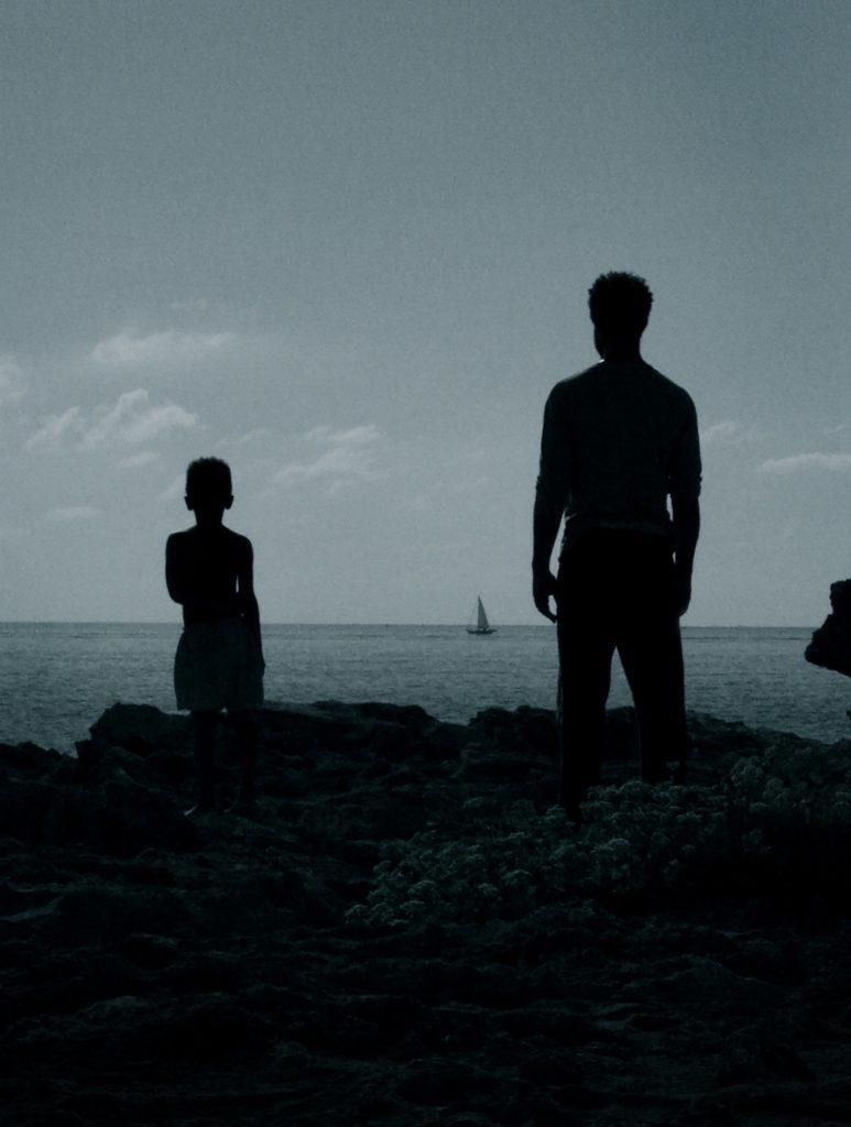 El actor Òscar Kapoya contempla un velero en la película 'El vientre del mar'