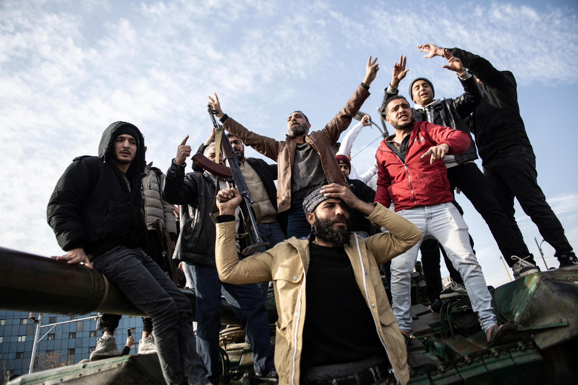 Un grupo de hombres de pie sobre un tanque celebra la entrada de los rebeldes sirios en Damasco, capital de Siria, este domingo. EFE/EPA/HASAN BELAL
