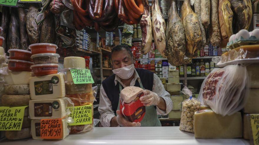Archivo - Un carnicero trabaja con mascarilla en un mercado.