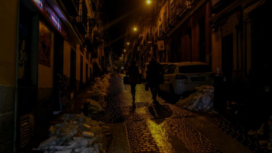 Un hombre y una mujer en una calle de Madrid de noche.