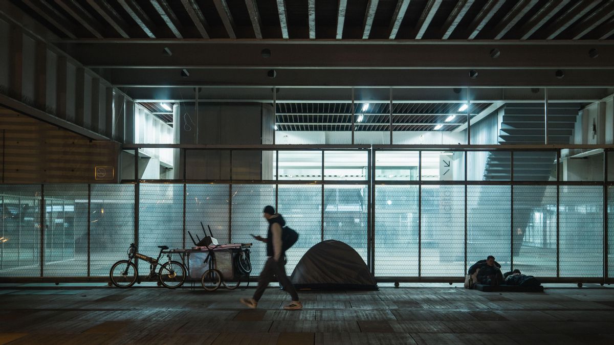 Una persona recorre la plaza Charles Darwin de Barcelona, donde pernoctan una quincena de personas cada noche