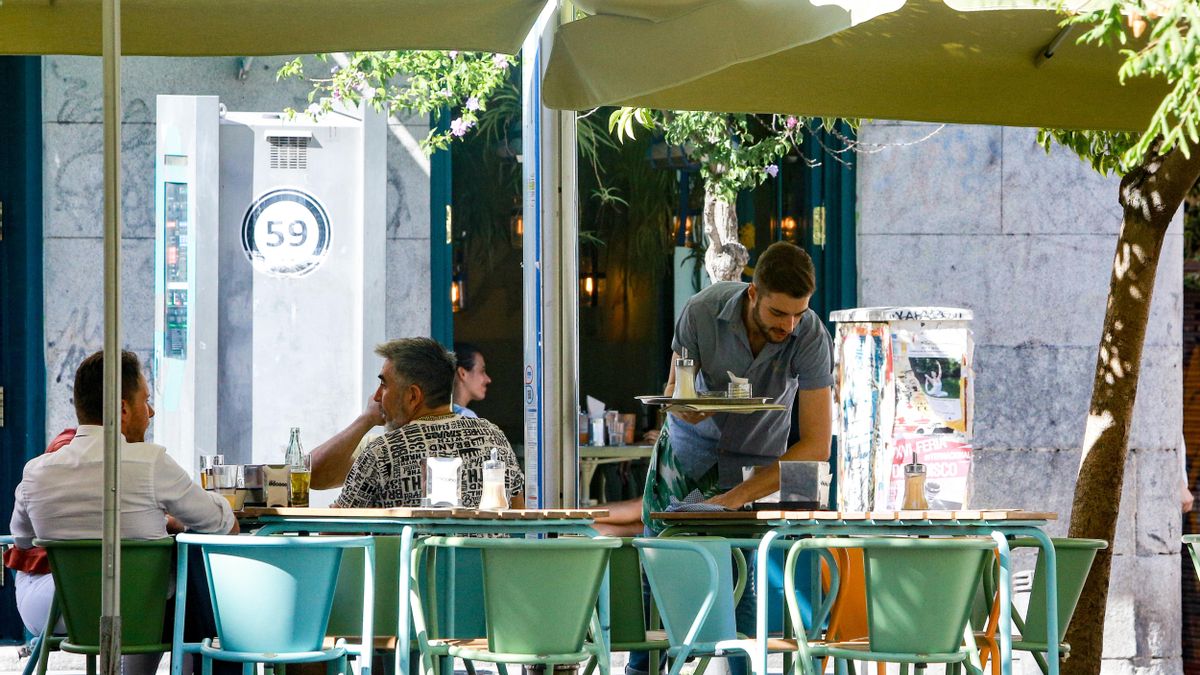 Un camarero trabaja en una terraza durante la época estival.