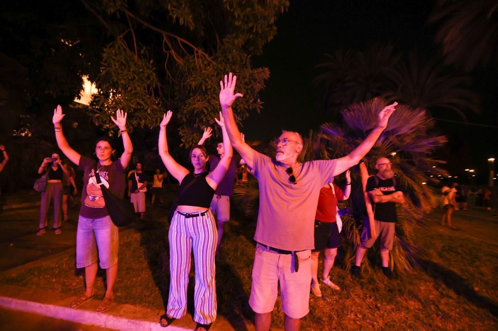 Alguns dels manifestants, amb els braços enlaire en senyal de pacifisme davant les càrregues policials
