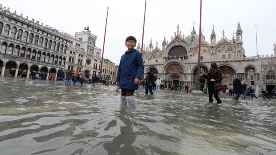 Un niño pasea por la inundada Plaza de San Marcos mientras las aguas comienzan a crecer, en Venecia (Italia).