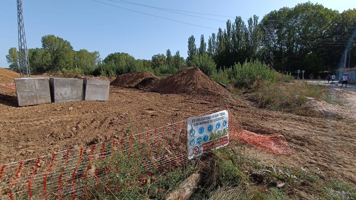Obras en el lateral de la Ronda Este LE-20 con el acceso principal del Parque de La Candamia al fondo.