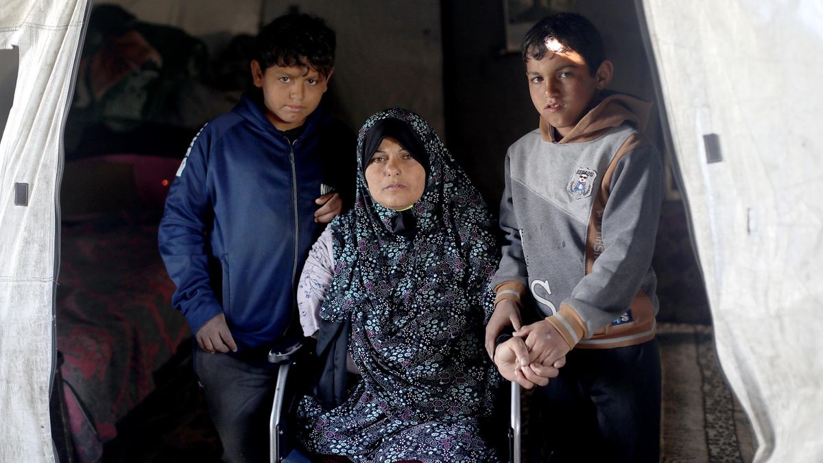 Maryam Abdullah con dos de sus hijos en el campamento de desplazados donde viven en Gaza, en marzo de 2026.