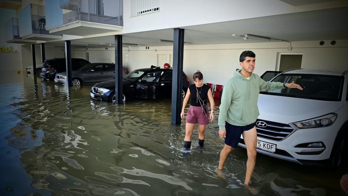 Raúl y Tania salen de su casa aún con un palmo de agua en la zona del aparcamiento.