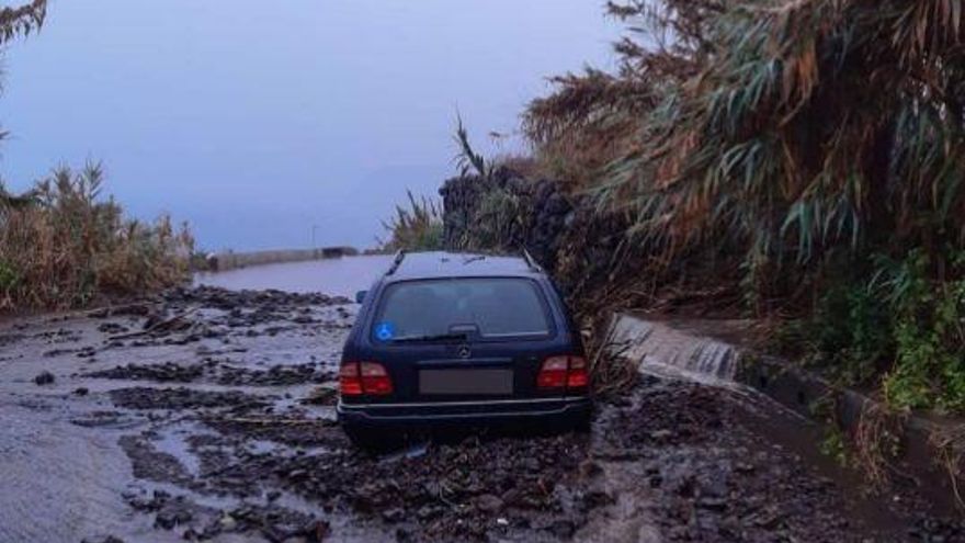 Un coche atrapado en el barro y alcantarillas desbordadas, entre los primeros destrozos de las lluvias en Canarias