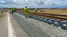 Un tren carrilero va dejando las vías sobre las traviesas
