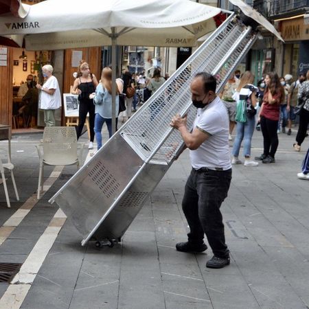 Un camarero recoge la terraza antes de las 18:30