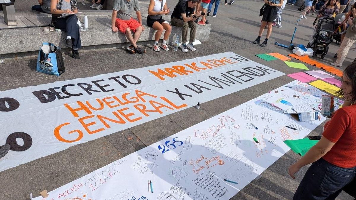 Los manifestantes que acampan en la Puerta el Sol preparan sus pancartas