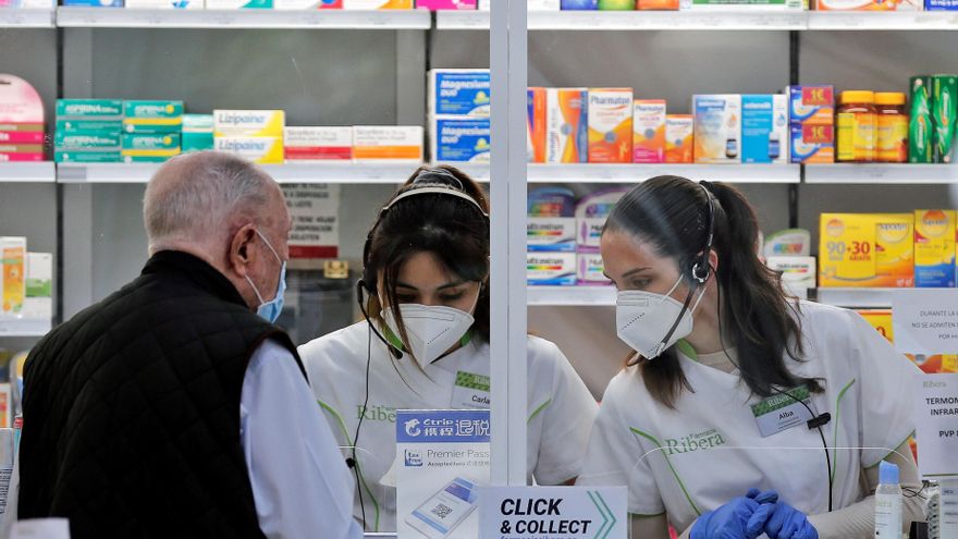 Dos empleadas de una farmacia atienden a un cliente. EFE/ Manuel Bruque/Archivo