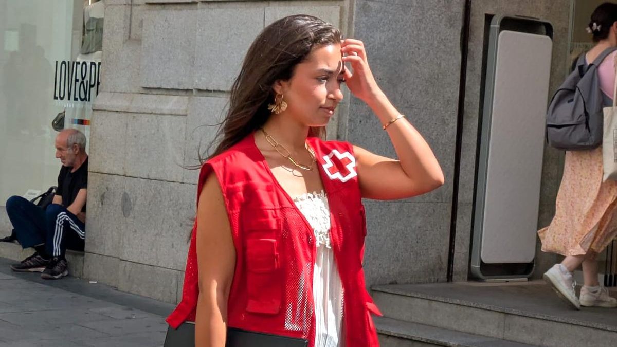 Una captadora de una ONG se tapa del sol una mañana de julio en la capital