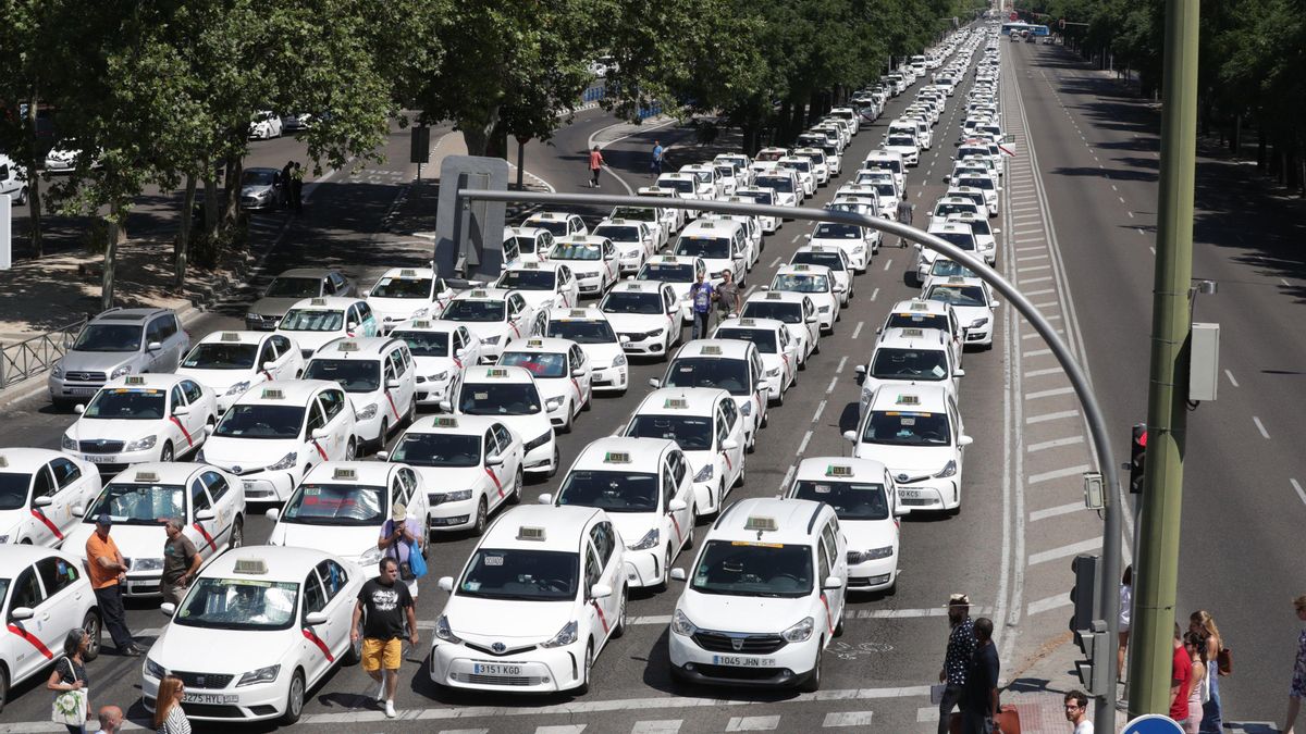 Un grupo de taxis permanecen concentrados a su paso por el ministerio de Fomento