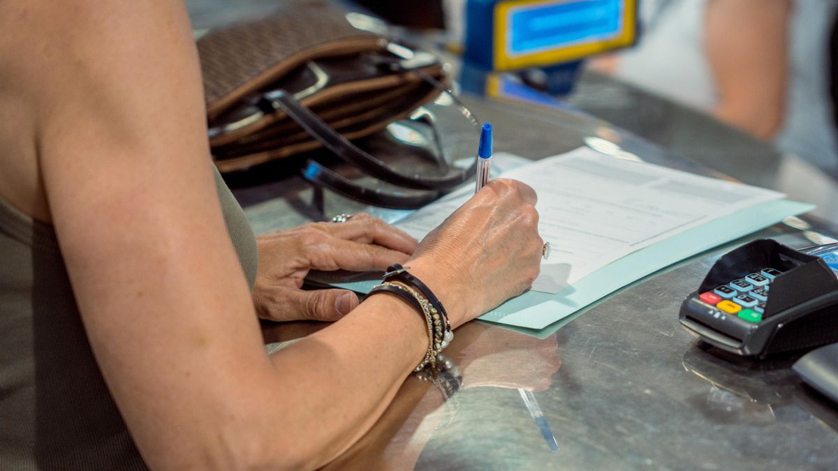 Una persona rellena unos documentos tras solicitar el voto por correo