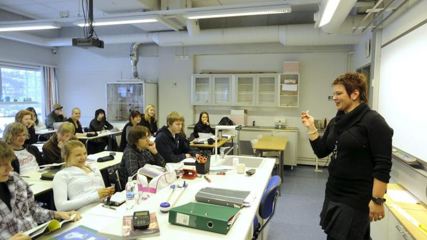 En la imagen, una profesora impartiendo la lección a sus alumnos.