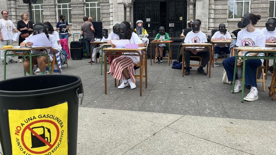 Protesta en la Plaza del Ayuntamiento de Santander contra la gasolinera que se está construyendo junto al IES Cantabria. Alumnos con máscaras antigás se sientan en pupitres en la calle y leen derechos que ven vulnerados con esta gasolinera