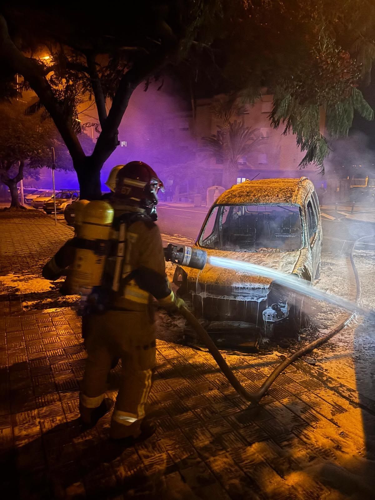 Un bombero apagando el fuego en el vehículo.