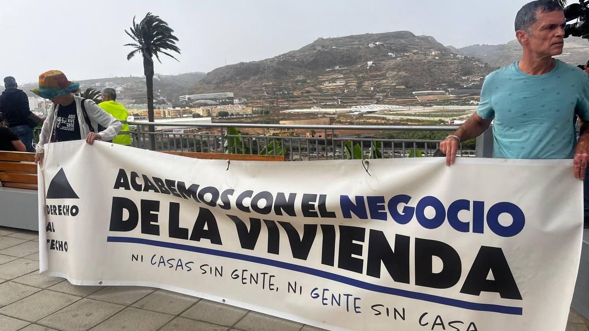 Marifé Navarro y Tito Martín sostienen frente al desahucio de Mr. Leacock una pancarta de Derecho al Techo.