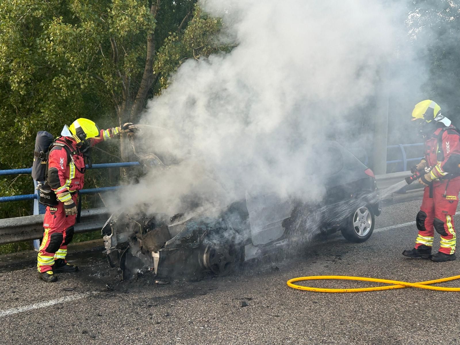 Los Bomberos de León se afanan para evitar peligro en el incendio del vehículo.
