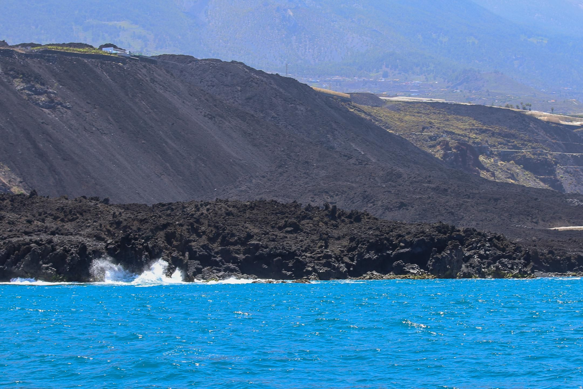 Vista de las fajanas del volcán Tajogaite desde el mar, en una excursión en barco organizada por la viceconsejería de Presidencia del Gobierno de Canarias como parte del proyecto "Rutas 2030". EFE / Luis G Morera