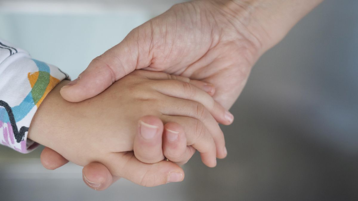 Teresa le da la mano a su hija de cinco años.