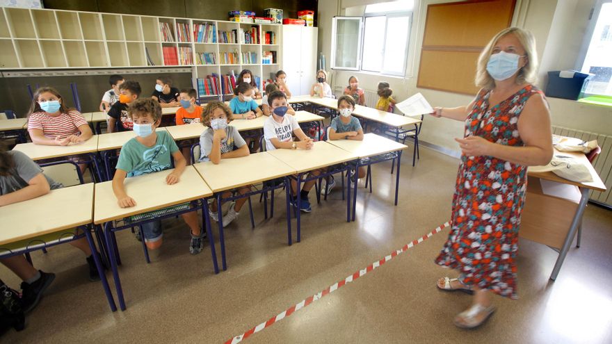 Una maestra en clase junto a sus alumnos de Primaria en el colegio Balmes de València.