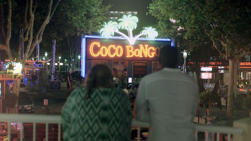 Neones un tanto decadentes contemplados por una pareja de 'currantes' que comparte piso