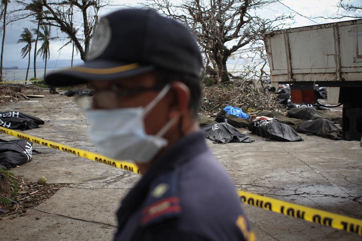 Un policía, en las cercanías del ayuntamiento de Tacloban, ayuda en las tareas de recuperación e identificación de cadáveres, el 14 de noviembre de 2013, Filipinas/ Fotografía: Acción contra el Hambre/Daniel Burgui.