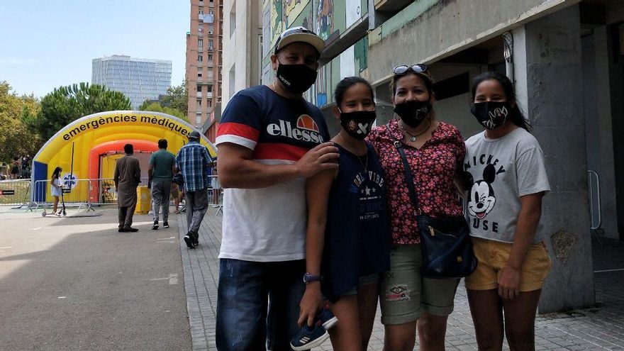 Julio y Milenca con sus dos hijas, frente al dispositivo móvil de PCR ubicado en el CAP Besòs