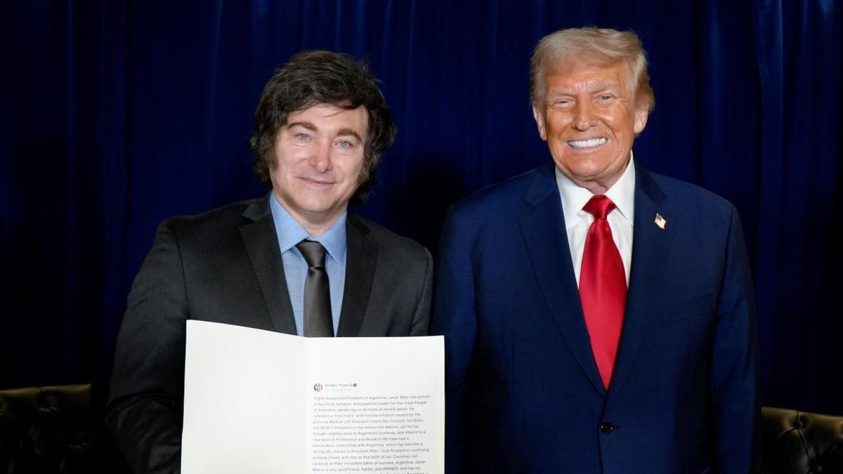 El presidente argentino, Javier Milei, posa junto a Donald Trump, mientras sostiene una copia impresa de un mensaje de apoyo del presidente de EEUU.