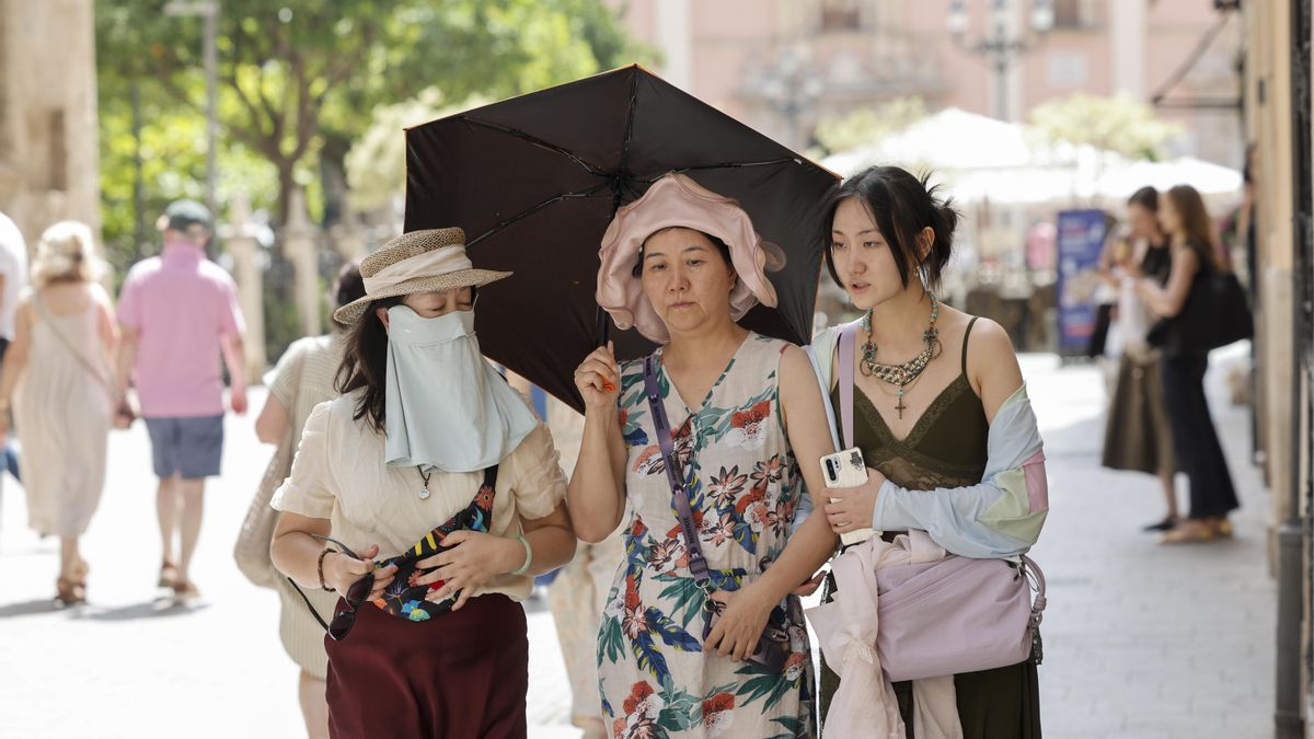 Tres turistas se protegen del sol y del calor Valencia