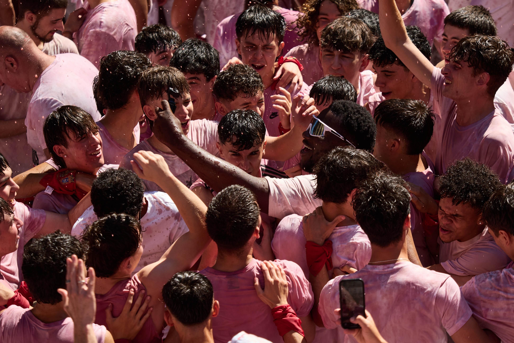 Grupos de asistentes comparten bebidas y momentos de ocio en la Plaza del Ayuntamiento, uno de los principales puntos de encuentro de San Fermín
