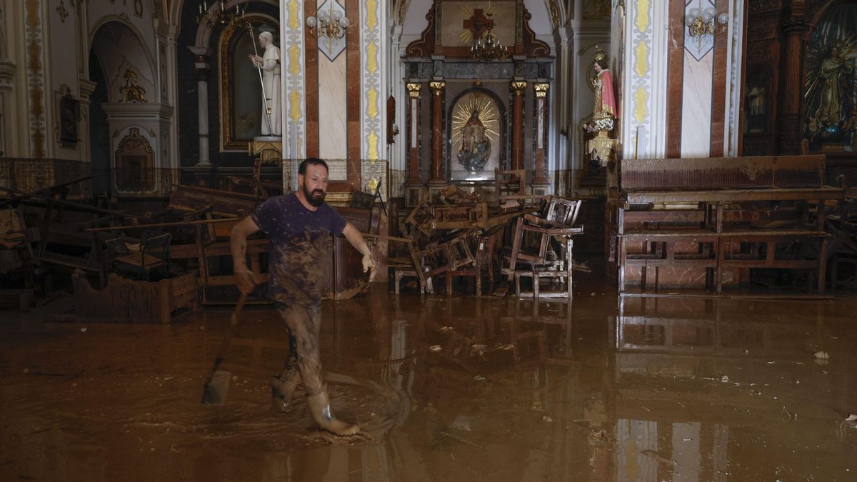 Un vecino de Paiporta limpiando el interior de una iglesia inundada por la dana
