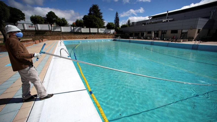 Un operario limpia una piscina.