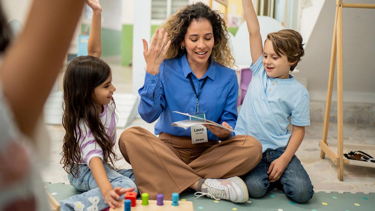 Una profesora leyendo un libro a niños en la guardería
