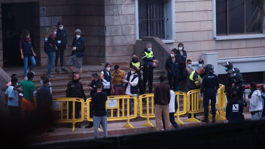 Uno de los migrantes del campamento de Las Raíces sale del edificio central con ayuda de dos trabajadoras de Accem tras los disturbios