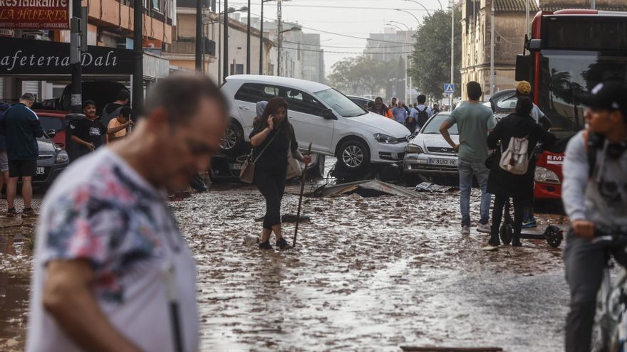 Varias personas realizan labores de limpieza tras el paso de la DANA por el barrio de La Torre de Valencia