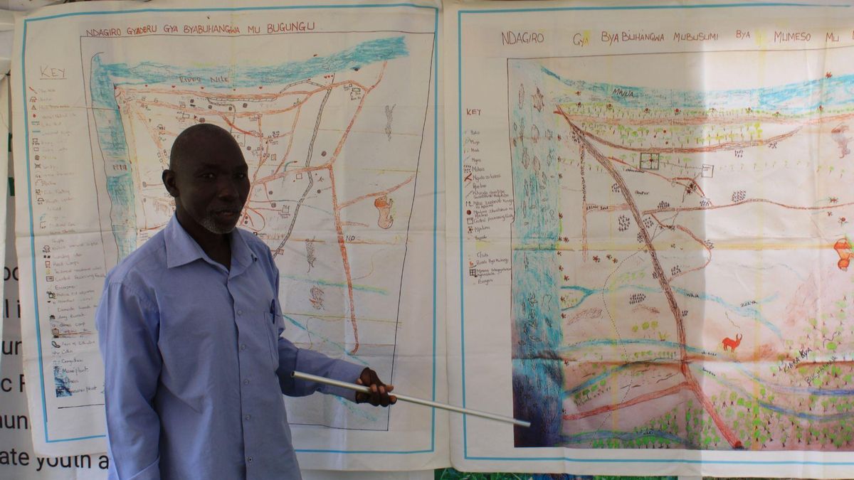 Guardián de uno de los ‘sitios naturales sagrados’ de la comunidad Bagungu mostrando los mapas ancestrales elaborados de la mano de la organización AFRICE.
