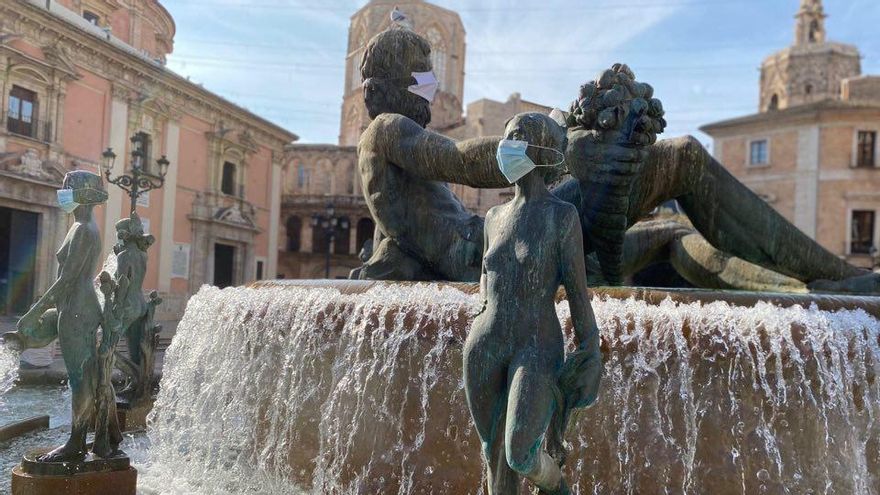 Las esculturas de la fuente de la plaza de la Virgen con las mascarillas.