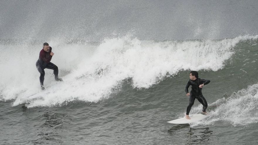 Los surfistas 'desafiaron' a la borrasca Herminia y disfrutaron entre las olas en la playa de San Lorenzo, en Gijón.