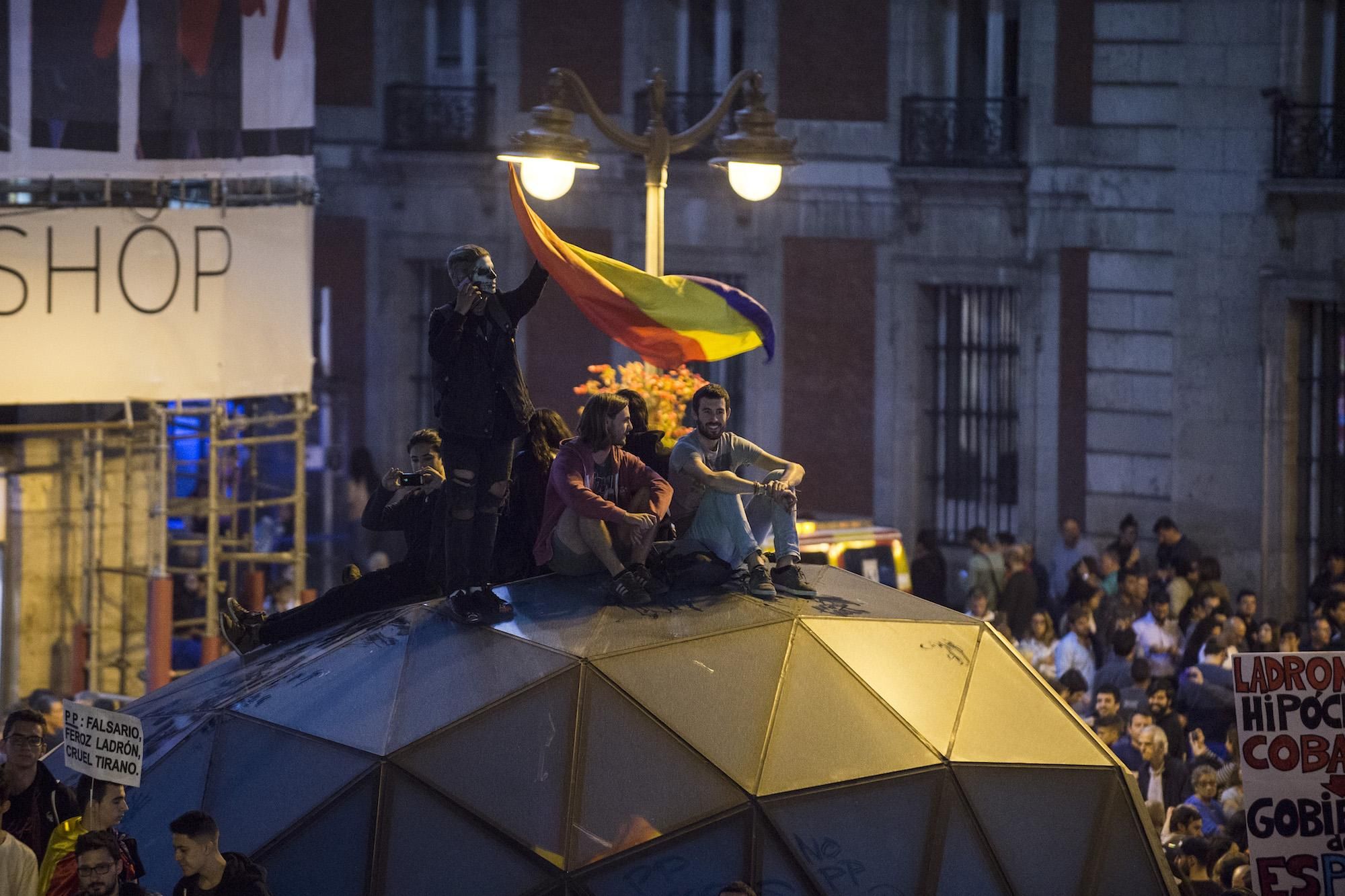 Manifestantes se encaraman a la cúpula de entrada y salida al Metro de Sol, al finalizar la manifestación "rodea el Congreso"