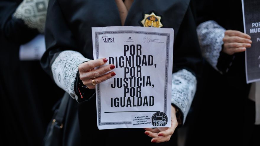 Una letrada de la Administración de Justicia sujeta un cartel reivindicativo