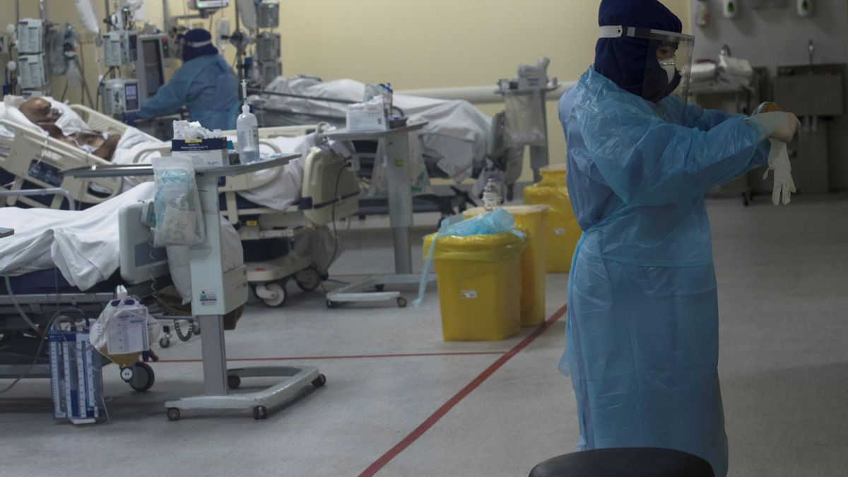 Una sanitaria se prepara para atender a un grupo de pacientes afectados por la COVID-19 en la Unidad de Cuidados Intensivos (UCI)